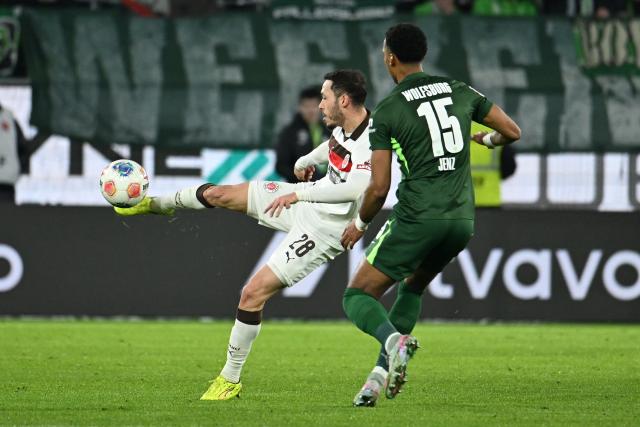 14 January 2026, Lower Saxony, Wolfsburg: St. Pauli's Mathias Pereira Lage (L) and Wolfsburg's Moritz Jenz battle for the ball during the German Bundesliga soccer match between VfL Wolfsburg and FC St. Pauli,  at Volkswagen Arena. Photo: Swen Pförtner/dpa - WICHTIGER HINWEIS: Gemäß den Vorgaben der DFL Deutsche Fußball Liga bzw. des DFB Deutscher Fußball-Bund ist es untersagt, in dem Stadion und/oder vom Spiel angefertigte Fotoaufnahmen in Form von Sequenzbildern und/oder videoähnlichen Fotostrecken zu verwerten bzw. verwerten zu lassen.