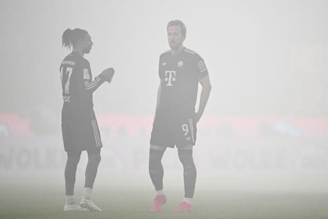 14 January 2026, North Rhine-Westphalia, Cologne: Bayern Munich's Harry Kane (R) talks to Michael Olise while the game is interrupted due to smoke from pyrotechnics during the German Bundesliga soccer match between 1. FC Cologne and Bayern Munich at RheinEnergieStadion. Photo: Federico Gambarini/dpa - IMPORTANT NOTICE: DFL and DFB regulations prohibit any use of photographs as image sequences and/or quasi-video.