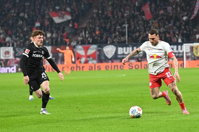 14 January 2026, Saxony, Leipzig: RB Leipzig's David Raum (R) and Freiburg's Philipp Treu battle for the ball during the German Bundesliga soccer match between RB Leipzig and SC Freiburg at Red Bull Arena. Photo: David Hammersen/dpa - WICHTIGER HINWEIS: Gemäß den Vorgaben der DFL Deutsche Fußball Liga bzw. des DFB Deutscher Fußball-Bund ist es untersagt, in dem Stadion und/oder vom Spiel angefertigte Fotoaufnahmen in Form von Sequenzbildern und/oder videoähnlichen Fotostrecken zu verwerten bzw. verwerten zu lassen.