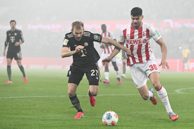 14 January 2026, North Rhine-Westphalia, Cologne: Cologne's Cenk Oezkacar (R) and Bayern Munich's Konrad Laimer battle for the ball during the German Bundesliga soccer match between 1. FC Cologne and Bayern Munich at RheinEnergieStadion. Photo: Federico Gambarini/dpa - IMPORTANT NOTICE: DFL and DFB regulations prohibit any use of photographs as image sequences and/or quasi-video.
