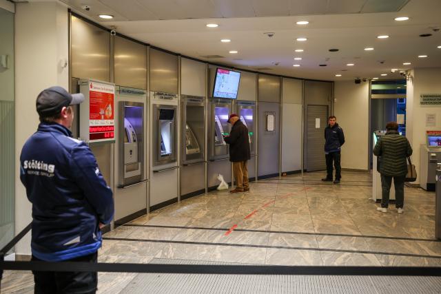 15 January 2026, North Rhine-Westphalia, Gelsenkirchen: Employees of a security company stand in the reopened self-service area of the Sparkasse branch in Gelsenkirchen, where customers can once again withdraw cash and obtain account statements. A little over two weeks after the million-euro break-in, the ATMs are back in service, while the branch itself remains closed. Photo: Christoph Reichwein/dpa