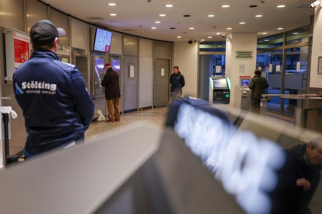 15 January 2026, North Rhine-Westphalia, Gelsenkirchen: Employees of a security company stand in the reopened self-service area of the Sparkasse branch in Gelsenkirchen, where customers can once again withdraw cash and obtain account statements. A little over two weeks after the million-euro break-in, the ATMs are back in service, while the branch itself remains closed. Photo: Christoph Reichwein/dpa