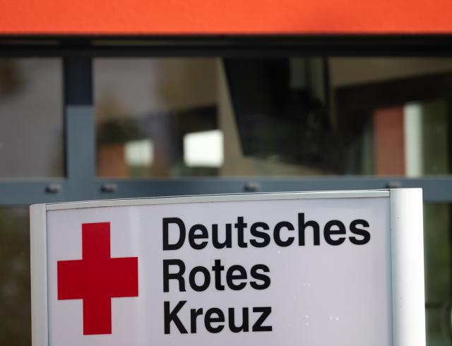 FILED - 10 October 2024, Berlin: A sign with the inscription "Deutsches Rotes Kreuz" (German Red Cross, DRK) stands in front of the entrance to a house. Photo: Soeren Stache/dpa