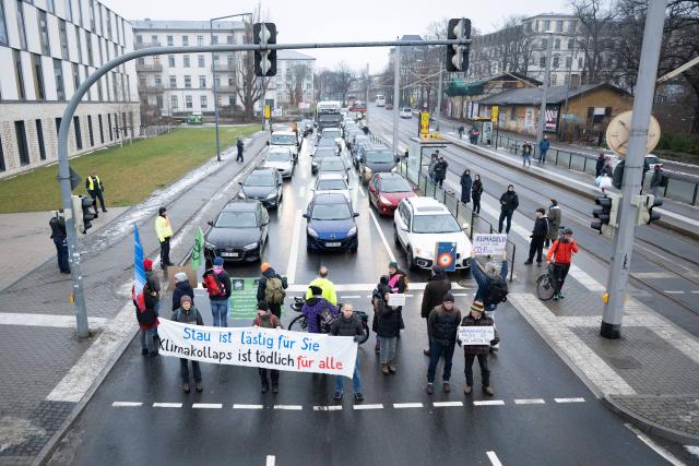 15 January 2026, Saxony, Dresden: Climate activists hold banners at Stauffenbergallee and Koenigsbruecker Strasse during an Extinction Rebellion demonstration in Dresden, calling for an end to fossil fuel heating and an ambitious heating plan. Photo: Sebastian Kahnert/dpa