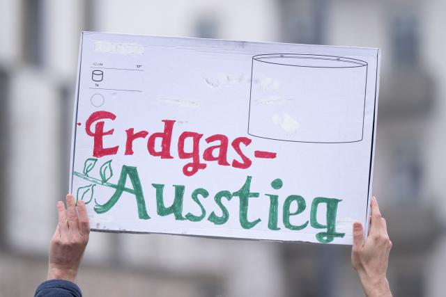 15 January 2026, Saxony, Dresden: A climate activist holds a sign reading "Erdgas-Ausstieg" (phase out natural gas) at Stauffenbergallee and Koenigsbruecker Strasse during an Extinction Rebellion demonstration in Dresden, calling for an end to fossil fuel heating and an ambitious heating plan. Photo: Sebastian Kahnert/dpa