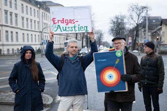 15 January 2026, Saxony, Dresden: Climate activist Christian Blaeul (2nd L) holds a sign reading "Erdgas-Ausstieg" (phase out natural gas) at the intersection of Stauffenbergallee and Koenigsbruecker Strasse during an Extinction Rebellion demonstration in Dresden. Activists call for phasing out fossil fuel heating and implementing an ambitious heating plan. Photo: Sebastian Kahnert/dpa