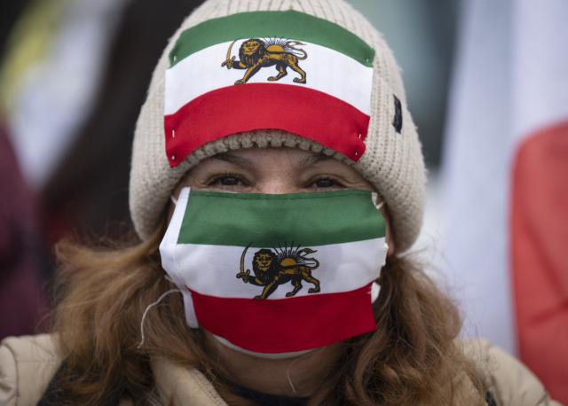 PRODUCTION - 15 January 2026, Hesse, Frankfurt/Main: A woman is seen with the old Iranian flag with the lion as Iranians protest in front of the US Consulate in Frankfurt, to demonstrate against the Iranian regime and call for the US to intervene in the conflict. Photo: Boris Roessler/dpa