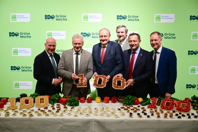 16 January 2026, Berlin: (L-R) Kai Wegner, Governing Mayor of Berlin, Alois Rainer, Germany's Minister for Food, Agriculture, and Rural Affairs, Joachim Rukwied, President of the German Farmers' Association, Christian von Boetticher, Chairman of the Federation of German Food and Drink Industries, Christophe Hansen, EU Commissioner for Agriculture and Food, and Mario Tobias, CEO of Messe Berlin, hold 100 sausages at the German Farmers' Association stand during the opening tour of the 90th International Green Week. Photo: Sebastian Christoph Gollnow/dpa