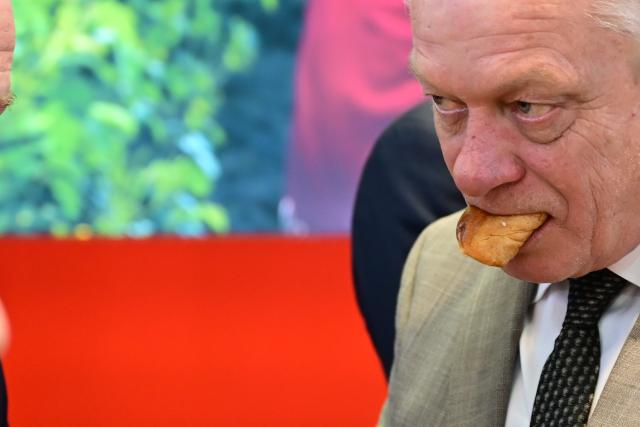 16 January 2026, Berlin: Alois Rainer, Germany's Minister of Food, Agriculture, and Rural Affairs, holds a pastry in his mouth during the opening tour at the start of the 90th International Green Week at the Bulgarian stand. Photo: Sebastian Christoph Gollnow/dpa