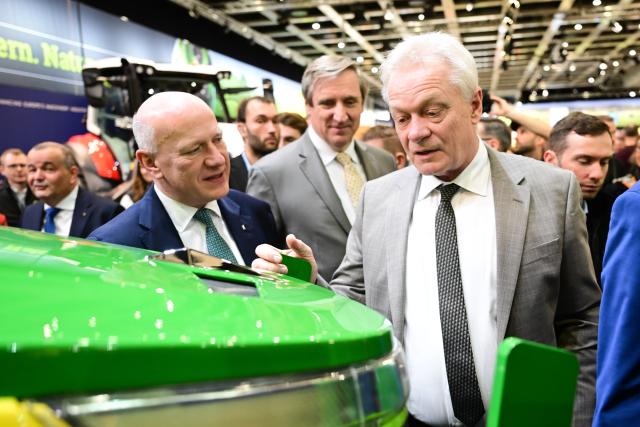 16 January 2026, Berlin: Kai Wegner (L), Governing Mayor of Berlin, and Alois Rainer (R), Germany's Minister for Food, Agriculture, and Home Affairs, walk past an electric tractor from John Deere during the opening tour at the start of the 90th International Green Week. Photo: Sebastian Christoph Gollnow/dpa