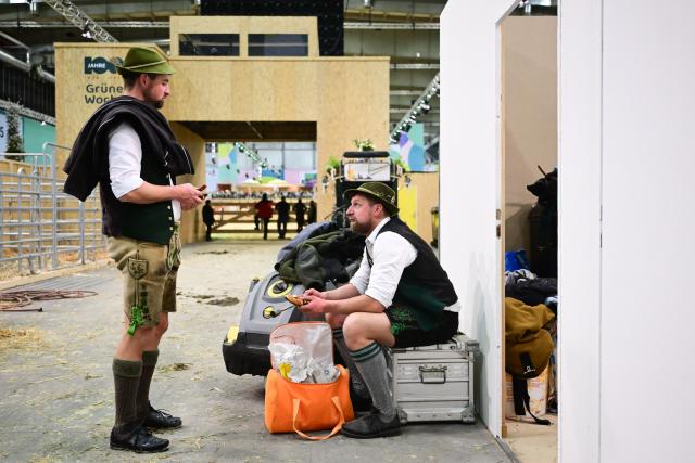 16 January 2026, Berlin: Coach drivers Josef and Sebastian from Bavaria take a break during the first day of the 90th International Green Week in the animal hall. Photo: Sebastian Christoph Gollnow/dpa