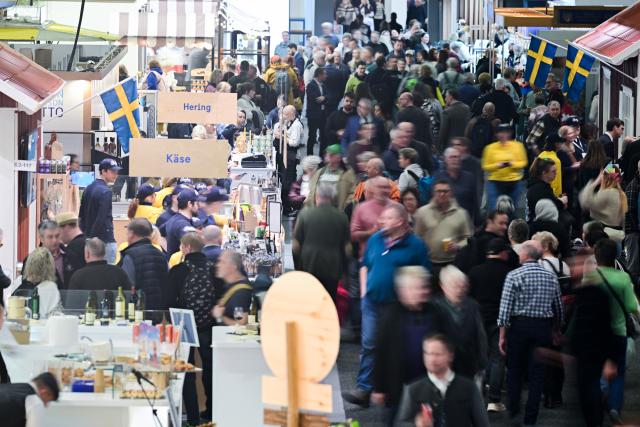 16 January 2026, Berlin: Visitors walk through a hall past stands from Sweden and Norway during the first day of the 90th International Green Week. The world's largest trade fair for food, agriculture and horticulture in Berlin is celebrating its 100th anniversary. Photo: Sebastian Christoph Gollnow/dpa