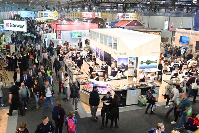 16 January 2026, Berlin: Visitors walk through a hall past stands from Sweden and Norway during the first day of the 90th International Green Week. The world's largest trade fair for food, agriculture and horticulture in Berlin is celebrating its 100th anniversary. Photo: Sebastian Christoph Gollnow/dpa