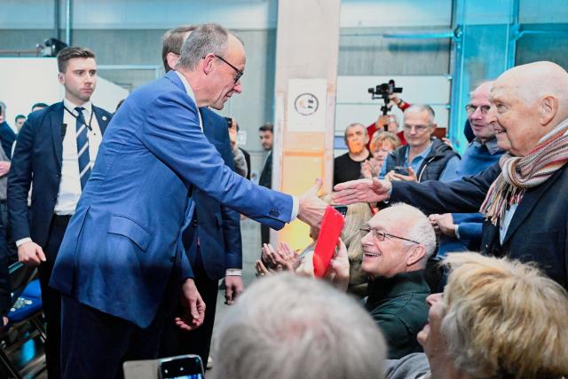 16 January 2026, Baden-Württemberg, Heddesheim: German Chancellor Friedrich Merz (C) shakes hands with an attendee during an election campaign event of the Christian Democratic Union at the Pfenning Logistics forwarding company in Heddesheim. Photo: Uwe Anspach/dpa