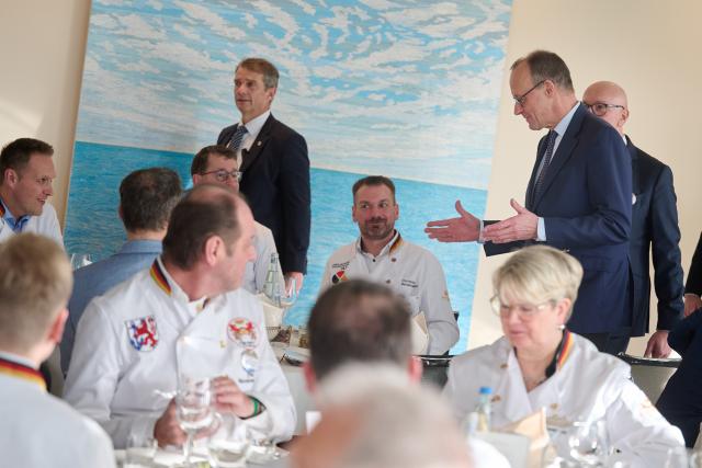 17 January 2026, North Rhine-Westphalia, Dortmund: Germany's Chancellor Friedrich Merz (R) enters the hall for the award ceremony, where he is presented with the 'Grosser Stutenkerl' (Big Stutenkerl) by the West German Bakers' Association. Since 1988, the roughly 1.2-metre-high, 10-kilogram baked figure has honored outstanding contributions to the baking trade and the craft industry. Photo: Bernd Thissen/dpa