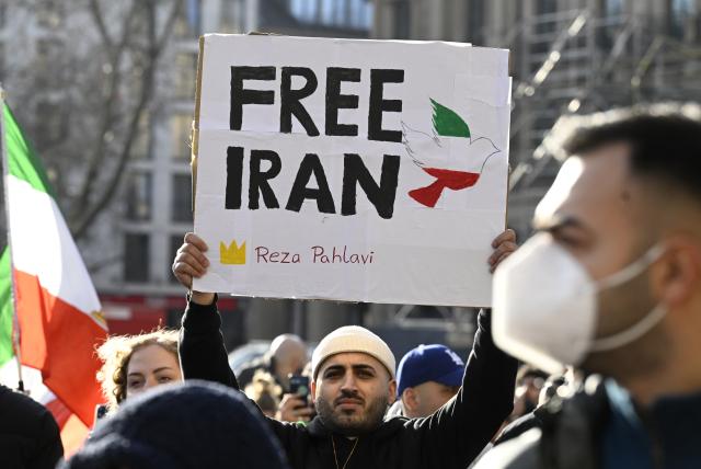 17 January 2026, North Rhine-Westphalia, Cologne: Participants hold signs and flags during a demonstration in Cologne in support of the protests in Iran. Photo: Roberto Pfeil/dpa