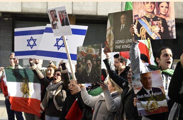 17 January 2026, North Rhine-Westphalia, Cologne: Participants hold signs and flags during a demonstration in Cologne in support of the protests in Iran. Photo: Roberto Pfeil/dpa