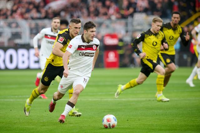 17 January 2026, North Rhine-Westphalia, Dortmund: Borussia Dortmund's Nico Schlotterbeck and St. Pauli's Arkadiusz Pyrka in action during the German Bundesliga soccer match between Borussia Dortmund and FC St. Pauli at the Signal Iduna Park. Photo: Bernd Thissen/dpa - IMPORTANT NOTICE: DFL and DFB regulations prohibit any use of photographs as image sequences and/or quasi-video.