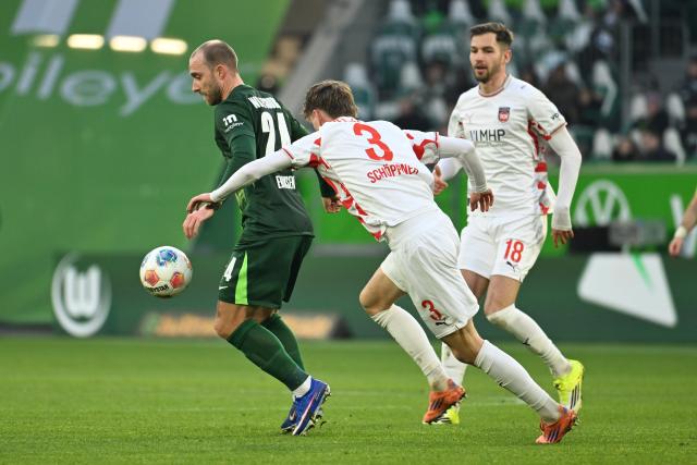 17 January 2026, Lower Saxony, Wolfsburg: Wolfsburg's Christian Eriksen (L) battles for the ball with Heidenheim's Jan Schoeppner and Marvin Pieringer (R) during the German Bundesliga soccer match between VfL Wolfsburg and 1. FC Heidenheim at Volkswagen Arena. Photo: Swen Pförtner/dpa - IMPORTANT NOTE: In accordance with the regulations of the DFL German Football League and the DFB German Football Association, it is prohibited to utilize or have utilized photographs taken in the stadium and/or of the match in the form of sequential images and/or video-like photo series.