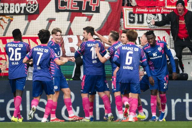 17 January 2026, North Rhine-Westphalia, Cologne: Mainz' Stefan Bell (C) celebrates scoring his side's first goal with his teammates during the German Bundesliga soccer match between 1. FC Cologne and FSV Mainz 05 at RheinEnergieStadion. Photo: Marius Becker/dpa - IMPORTANT NOTE: In accordance with the regulations of the DFL German Football League and the DFB German Football Association, it is prohibited to utilize or have utilized photographs taken in the stadium and/or of the match in the form of sequential images and/or video-like photo series.
