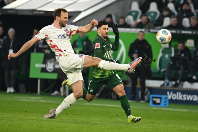 17 January 2026, Lower Saxony, Wolfsburg: Heidenheim's Benedikt Gimber and Wolfsburg's Mohamed Amoura battle for the ball during the German Bundesliga soccer match between VfL Wolfs burg and 1. FC Heidenheim at Volkswagen Arena. Photo: Swen Pförtner/dpa - IMPORTANT NOTE: In accordance with the regulations of the DFL German Football League and the DFB German Football Association, it is prohibited to utilize or have utilized photographs taken in the stadium and/or of the match in the form of sequential images and/or video-like photo series.
