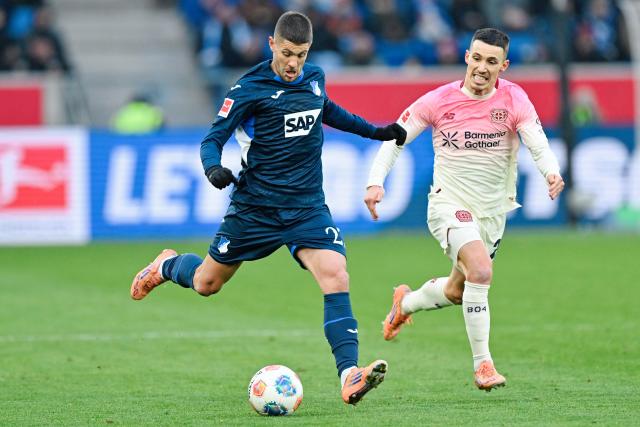 17 January 2026, Baden-Württemberg, Sinsheim: Hoffenheim's Andrej Kramaric and Bayer Leverkusen's Alex Grimaldo battle for the ball during the German Bundesliga soccer match between TSG 1899 Hoffenheim and Bayer Leverkusen at the PreZero Arena. Photo: Uwe Anspach/dpa - IMPORTANT NOTICE: DFL and DFB regulations prohibit any use of photographs as image sequences and/or quasi-video.