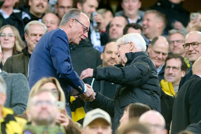 17 January 2026, North Rhine-Westphalia, Dortmund: German Chancellor Friedrich Merz greets former BVB president Reinhard Rauball as he takes his seat in the stands during the German Bundesliga soccer match between Borussia Dortmund and FC St. Pauli at the Signal Iduna Park. Photo: Bernd Thissen/dpa - IMPORTANT NOTICE: DFL and DFB regulations prohibit any use of photographs as image sequences and/or quasi-video.