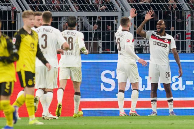 17 January 2026, North Rhine-Westphalia, Dortmund: St. Pauli's Ricky-Jade Jones (R) celebrates scoring his side's second goal with James Sands during the German Bundesliga soccer match between Borussia Dortmund and FC St. Pauli at the Signal Iduna Park. Photo: Bernd Thissen/dpa - IMPORTANT NOTICE: DFL and DFB regulations prohibit any use of photographs as image sequences and/or quasi-video.