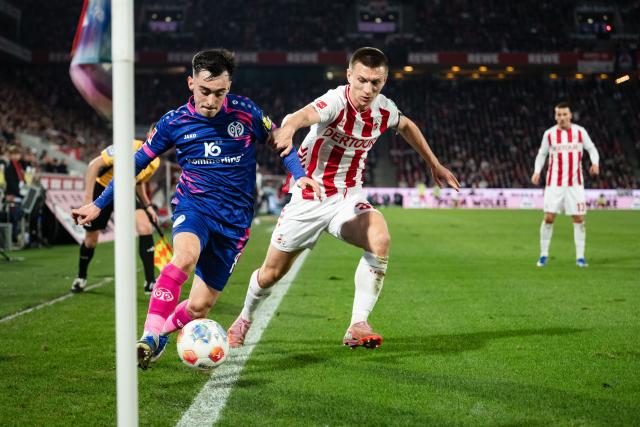 17 January 2026, North Rhine-Westphalia, Cologne: Mainz Paul Nebel (L) and Cologne's Kristoffer Lund battle for the ball during the German Bundesliga soccer match between 1. FC Cologne and FSV Mainz 05 at RheinEnergieStadion. Photo: Marius Becker/dpa - IMPORTANT NOTE: In accordance with the regulations of the DFL German Football League and the DFB German Football Association, it is prohibited to utilize or have utilized photographs taken in the stadium and/or of the match in the form of sequential images and/or video-like photo series.