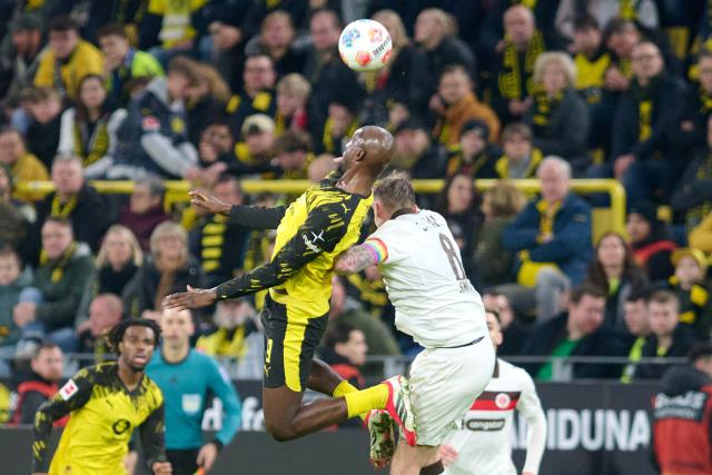 17 January 2026, North Rhine-Westphalia, Dortmund: Borussia Dortmund's Serhou Guirassy and St. Pauli's Eric Smith (R) in action during the German Bundesliga soccer match between Borussia Dortmund and FC St. Pauli at the Signal Iduna Park. Photo: Bernd Thissen/dpa - IMPORTANT NOTICE: DFL and DFB regulations prohibit any use of photographs as image sequences and/or quasi-video.