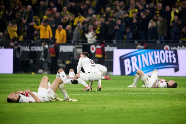 17 January 2026, North Rhine-Westphalia, Dortmund: St. Pauli's James Sands (C) kneels between his teammates after the German Bundesliga soccer match between Borussia Dortmund and FC St. Pauli at the Signal Iduna Park. Photo: Bernd Thissen/dpa - IMPORTANT NOTICE: DFL and DFB regulations prohibit any use of photographs as image sequences and/or quasi-video.