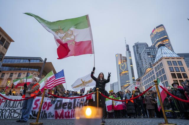 17 January 2026, Hesse, Frankfurt_Main: A participant waves an Iranian national flag during a rally against the regime in Iran on Rathenauplatz. Photo: Andreas Arnold/dpa