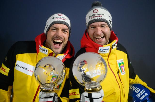 17 January 2026, Saxony, Altenberg: Germany's Johannes Lochner (R) and Georg Fleischhauer  celebrate holding the crystal globes after the second run of men's two-man bobsleigh competition during the IBSF Bobsleigh World Cup in Altenberg. Photo: Robert Michael/dpa