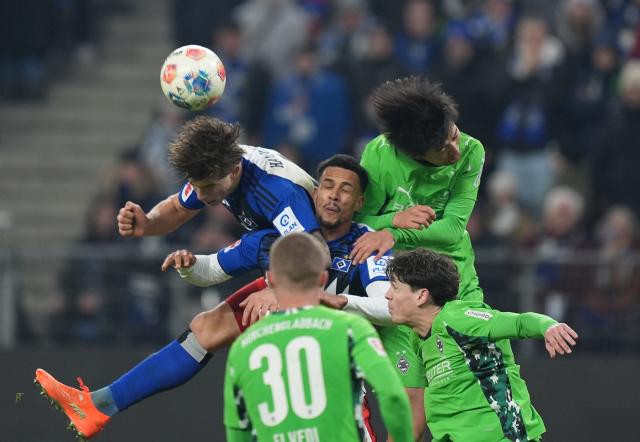 17 January 2026, Hamburg: Hamburg's Luka Vuskovizc (L) and Robert Glatzel battle for the ball with Moenchengladbach's Kota Takai during the German Bundesliga soccer match between Hamburger SV and Borussia Moenchengladbach at Volksparkstadion. Photo: Marcus Brandt/dpa - IMPORTANT NOTICE: DFL and DFB regulations prohibit any use of photographs as image sequences and/or quasi-video.