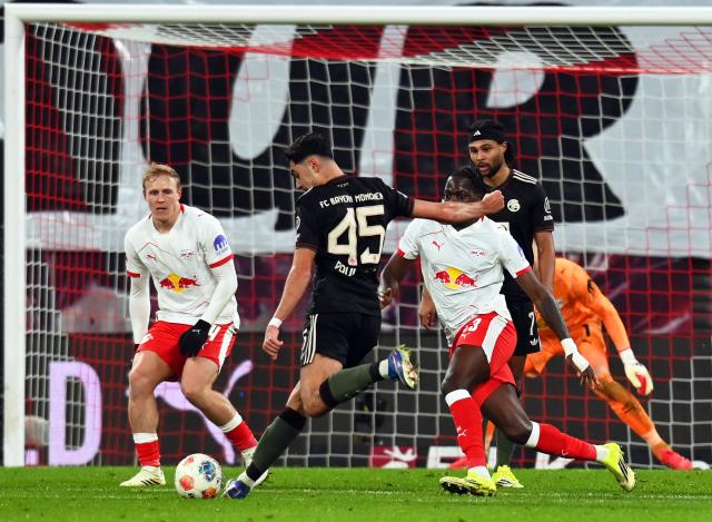 17 January 2026, Saxony, Leipzig: Bayern Munich's Aleksandar Pavlovic (2nd L) takes a shot on goal against Leipzig's Nicolas Seiwald and Castello Lukeba during the German Bundesliga soccer match between RB Leipzig and Bayern Munich at rhe Red bull Arena. Photo: David Hammersen/dpa