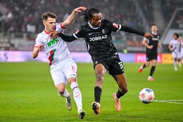 18 January 2026, Bavaria, Augsburg: Augsburg's Robin Fellhauer (L) and Freiburg's Jordy Makengo battle for the ball during the German Bundesliga soccer match between FC Augsburg and SC Freiburg at WWK Arena. Photo: Harry Langer/dpa - WICHTIGER HINWEIS: Gemäß den Vorgaben der DFL Deutsche Fußball Liga bzw. des DFB Deutscher Fußball-Bund ist es untersagt, in dem Stadion und/oder vom Spiel angefertigte Fotoaufnahmen in Form von Sequenzbildern und/oder videoähnlichen Fotostrecken zu verwerten bzw. verwerten zu lassen.
