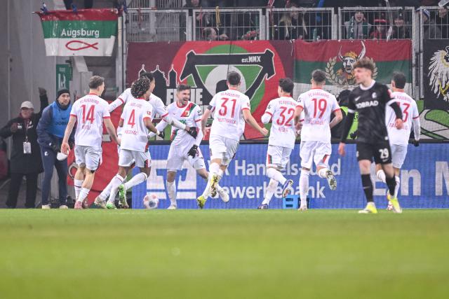 18 January 2026, Bavaria, Augsburg: Augsburg's Elvis Rexhbecaj (C) celebrates scoring his side's second goal with teammates during the German Bundesliga soccer match between FC Augsburg and SC Freiburg at WWK Arena. Photo: Harry Langer/dpa - WICHTIGER HINWEIS: Gemäß den Vorgaben der DFL Deutsche Fußball Liga bzw. des DFB Deutscher Fußball-Bund ist es untersagt, in dem Stadion und/oder vom Spiel angefertigte Fotoaufnahmen in Form von Sequenzbildern und/oder videoähnlichen Fotostrecken zu verwerten bzw. verwerten zu lassen.