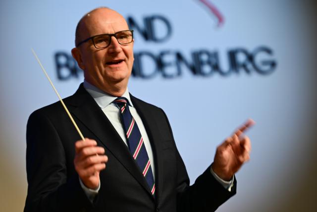19 January 2026, Berlin: Dietmar Woidke, Minister President of Brandenburg, conducts the state police orchestra during a tour of the Brandenburg Day of the 90th International Green Week at the opening. The world's largest trade fair for food, agriculture and horticulture in Berlin celebrates its 100th anniversary. Photo: Sebastian Christoph Gollnow/dpa