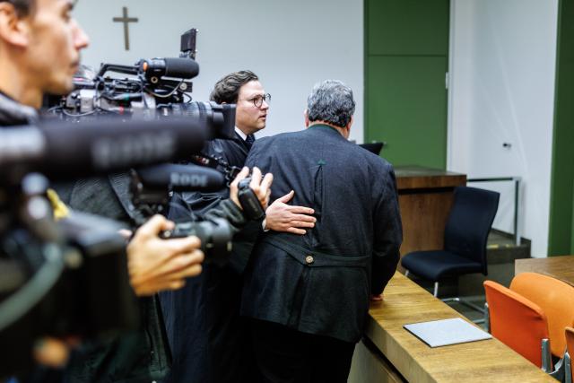 19 January 2026, Bavaria, Munich: An accused railway employee (R) walks past journalists on his way to his lawyer Maximilian Heim before the start of the trial for the fatal train accident in Garmisch-Partenkirchen on June 3, 2022, in the courtroom of the Munich II Regional Court. Two railway employees are charged with negligent homicide and negligent bodily injury. Photo: Matthias Balk/dpa