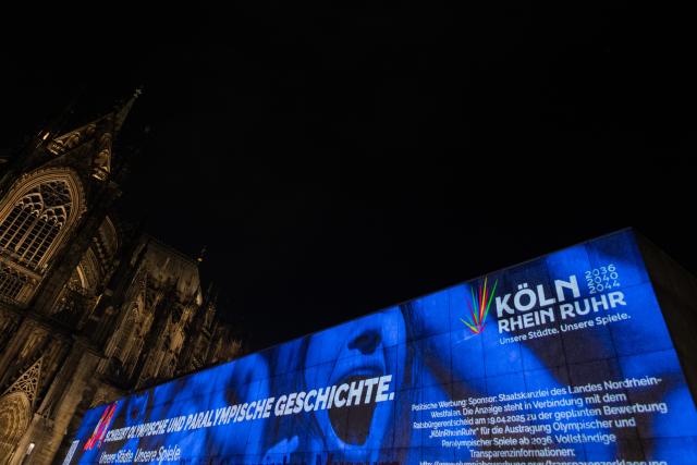 19 January 2026, North Rhine-Westphalia, Cologne: A projection on the Romano-Germanic Museum next to the cathedral on Roncalliplatz promotes the CologneRhineRuhr campaign, with Cologne as the "leading city," for the Olympic and Paralympic Games. Light and video installations by Bielefeld artist Hans-Christoph Muecke in four cities are intended to attract attention in public spaces. Photo: Rolf Vennenbernd/dpa