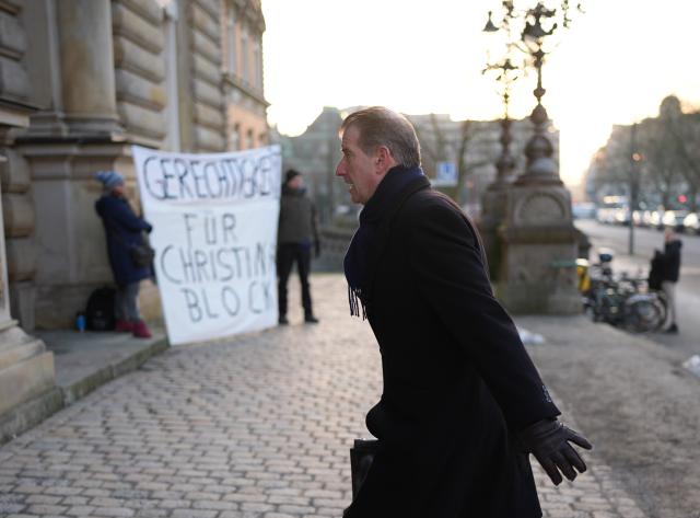 20 January 2026, Hamburg: Co-plaintiff Stephan Hensel, ex-husband and father of C. Block's children, walks past demonstrators on his way to another day of hearings in the alleged child abduction trial at the Hamburg Regional Court. In a cloak-and-dagger operation on New Year's Eve 2023/24, two of Block's children were brought from Denmark to Germany. Photo: Marcus Brandt/dpa