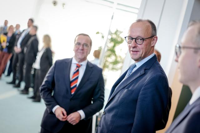 20 January 2026, Berlin: German Chancellor Friedrich Merz (C) arrives with Defence Minister Boris Pistorius (L) at the New Year's reception for families of soldiers and police officers on foreign missions. Photo: Kay Nietfeld/dpa