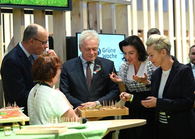 20 January 2026, Berlin: (L-R) German Chancellor Friedrich Merz, Alois Rainer, German Minister of Food, Agriculture and Home Affairs, Dorothee Baer, German Minister of Research, Technology and Space, and Silvia Breher, Parliamentary State Secretary at the Federal Ministry of Agriculture, Food and Home Affairs, sample canapes during a tour of the 90th International Green Week. Photo: Britta Pedersen/dpa