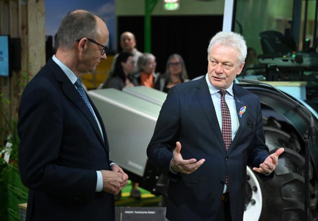 20 January 2026, Berlin: German Chancellor Friedrich Merz speaks to Alois Rainer,  German Minister of Food, Agriculture and Home Affairs,  during a tour of the 90th International Green Week. Photo: Britta Pedersen/dpa