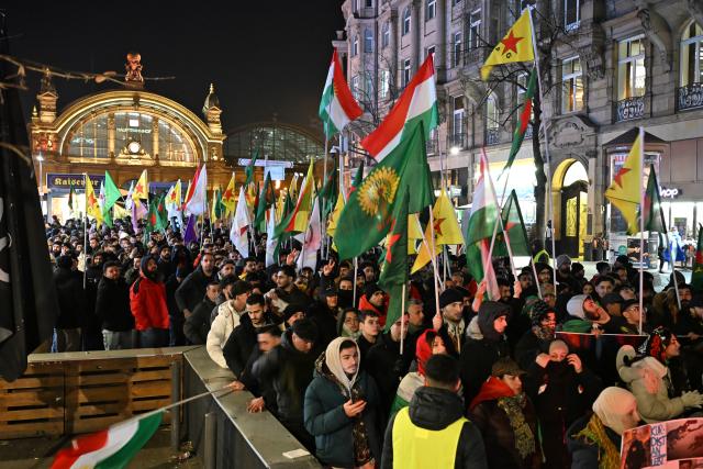 21 January 2026, Hesse, Frankfurt/Main: People walk down the street in front of the train station during a pro-Kurdish demonstration called for greater solidarity with Kurds in Syria. Photo: Michael Brandt/dpa