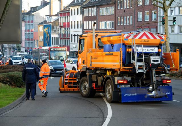 22 January 2026, North Rhine-Westphalia, Aachen: Roadblocks with winter road clearance vehicles prevent access to the evacuation area before an aerial bomb is defused. Before defusing the 250-kilogram aerial bomb discovered during construction work, the area around the discovery site is to be evacuated within a 400-meter radius. Photo: Henning Kaiser/dpa