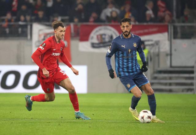22 January 2026, Baden-Wuerttemberg, Freiburg im Breisgau: Freiburg's Max Rosenfelder (L) and Maccabi Tel Aviv's Sagiv Yehezkel battle for the ball during the UEFA Europa League soccer match between SC Freiburg and Maccabi Tel Aviv at Europa-Park Stadium. Photo: Philipp von Ditfurth/dpa