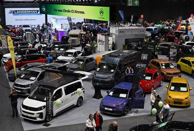 23 January 2026, Thuringia, Erfurt: Visitors view new cars at a stand at the 18th motor show at Messe Erfurt. From 23 to 25 January 2026, Germany's largest regional motor show, according to the organizers, will offer classic cars and market novelties as well as driving fun to watch and try out for yourself in three halls including an outdoor area. Photo: Martin Schutt/dpa