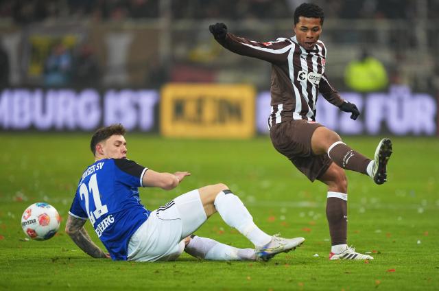 23 January 2026, Hamburg: Hamburger's Nicolai Remberg (L) and St. Pauli's Joel Chima Fujita battle for the ball during the German Bundesliga soccer match between FC St. Pauli and Hamburger SV at Millerntor Stadium. Photo: Marcus Brandt/dpa - IMPORTANT NOTICE: DFL and DFB regulations prohibit any use of photographs as image sequences and/or quasi-video.