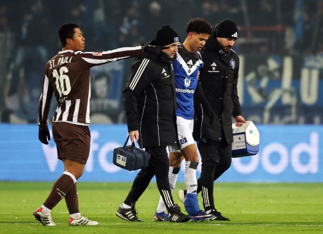 23 January 2026, Hamburg: Hamburger's Alexander Roessing-Lelesiit (2nd R) leaves the field due to injury during the German Bundesliga soccer match between FC St. Pauli and Hamburger SV at Millerntor Stadium. Photo: Christian Charisius/dpa - IMPORTANT NOTICE: DFL and DFB regulations prohibit any use of photographs as image sequences and/or quasi-video.
